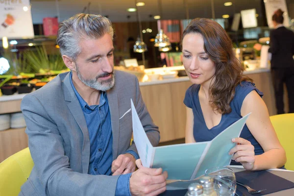 Pareja restausmiling con menú en el restaurante — Foto de Stock