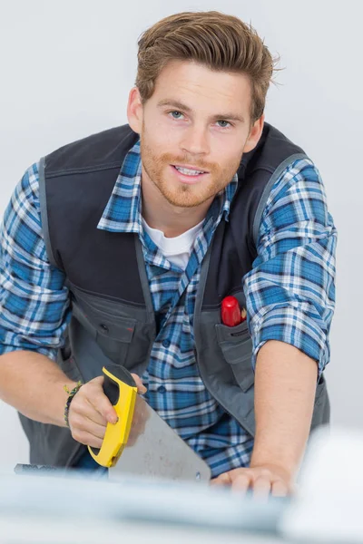 Worker works with handsaw — Stock Photo, Image