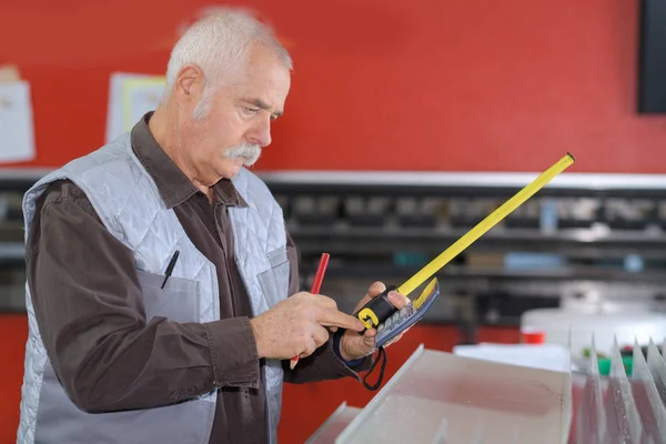 Senior-Schreiner Hände markieren ein Maß auf einer Holzplanke — Stockfoto