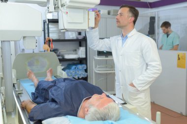 female doctor with male patient undergoing scanner clipart