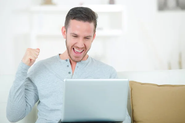 Hombre feliz sonriendo delante de la computadora portátil —  Fotos de Stock