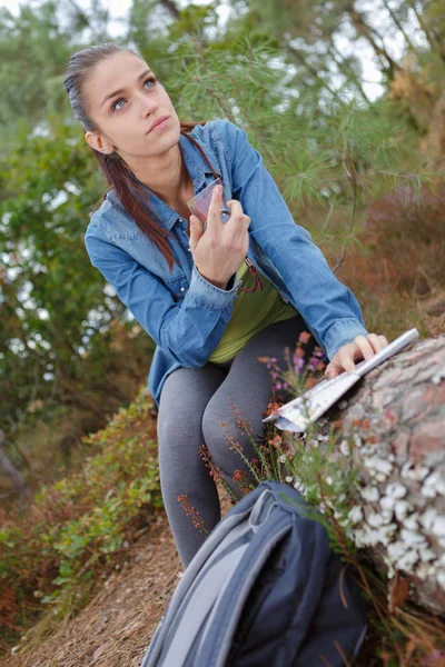 Beautiful young female hiker resting against a tree — Stock Photo, Image
