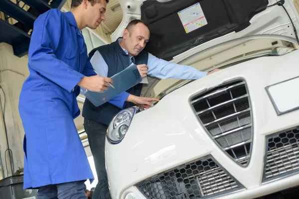 Deux mécaniciens travaillant sur une voiture — Photo