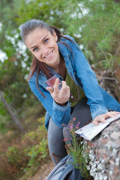 Ung turist kvinna med kompass vandring i skogen spår — Stockfoto