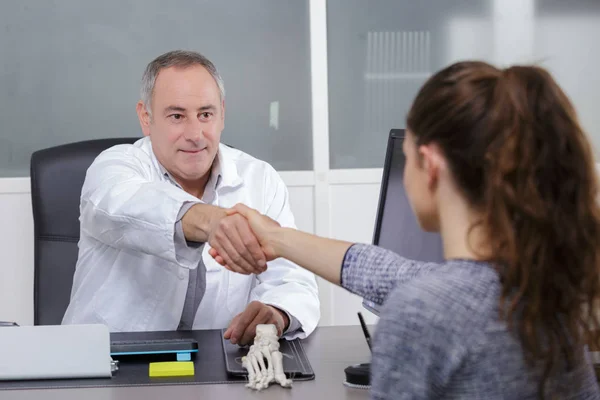 Aantrekkelijke mannelijke arts een patiënten schudden handen in zijn kantoor — Stockfoto