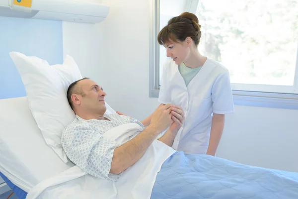 Sosteniendo paciente mano y enfermera — Foto de Stock