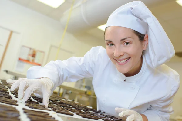 Chef arranging cookies and chef — Stock Photo, Image