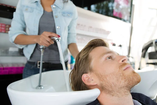 Homem tendo cabelo lavado no salão de beleza — Fotografia de Stock