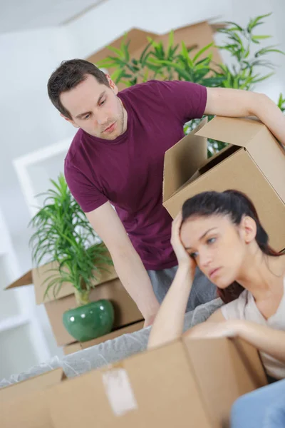 Busy man packing books and tired wife — Stock Photo, Image
