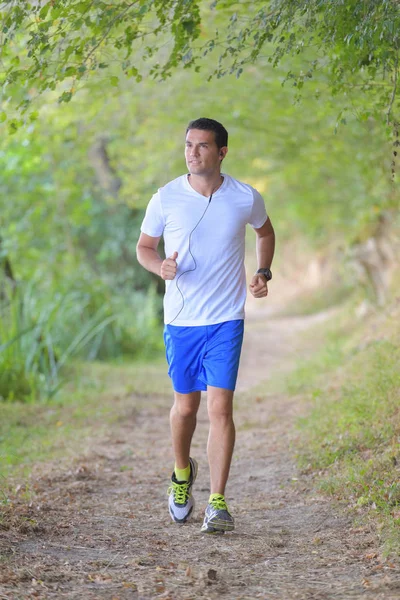 Jonge trail runner man joggen in de ochtend park — Stockfoto