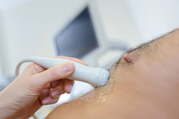 Dokter ultrasone sonde plaatsen op mannelijke patiënten borst — Stockfoto