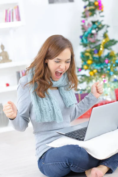 Mujer feliz joven con portátil y fondo de árbol de Navidad —  Fotos de Stock