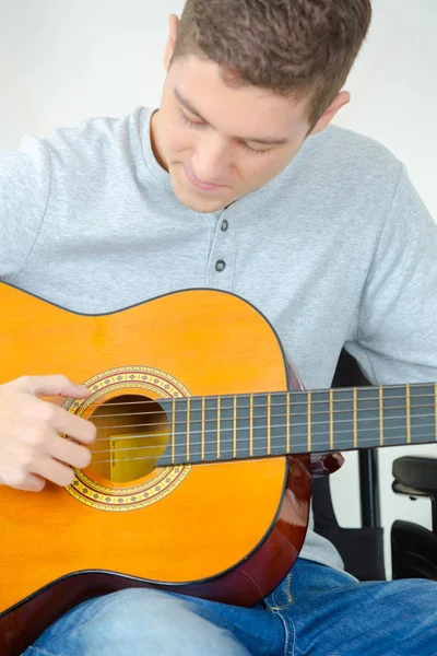 Junger Mann spielt Gitarre und komponiert ein Lied — Stockfoto