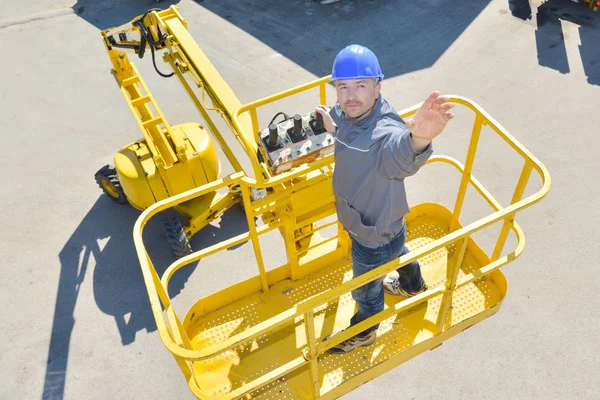 Homme sur grue ascenseur jusqu'à nettoyer la fenêtre — Photo