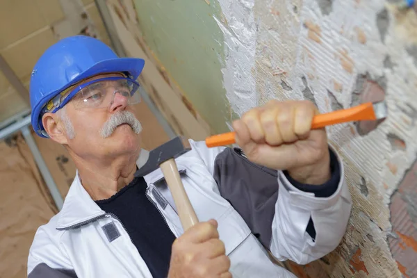 Bauarbeiter kratzt an der Wand — Stockfoto