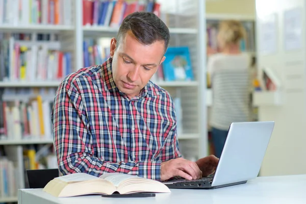 Pesquisador em biblioteca e homem — Fotografia de Stock