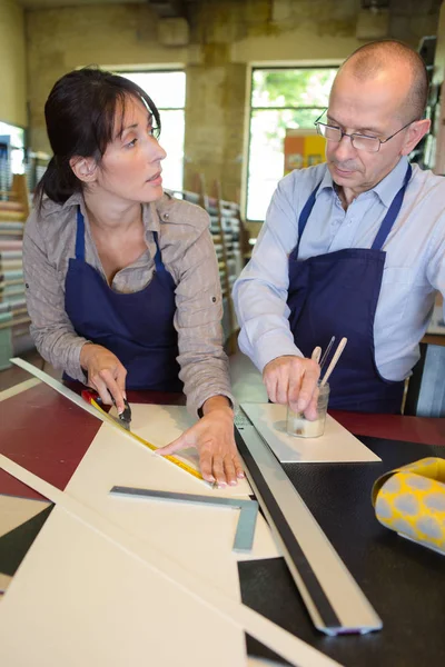 Two carpenters are talking while holding papers and ruler — Stock Photo, Image