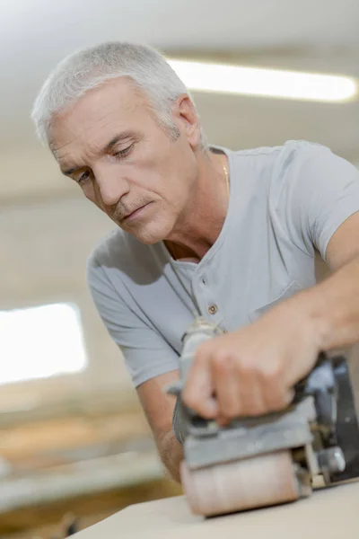 Timmerman met behulp van een riem schuurmachine — Stockfoto