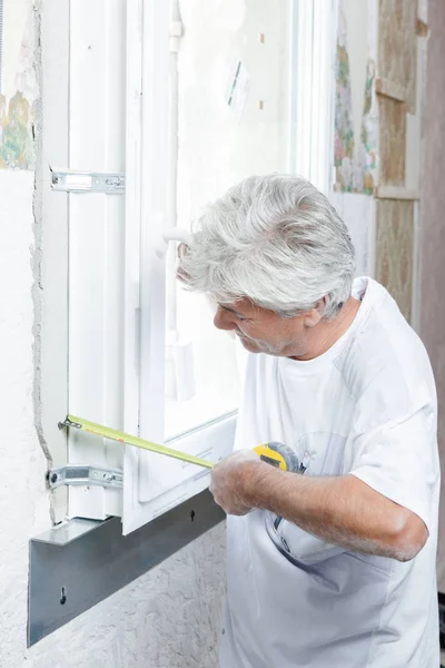 Measuring a window and builder — Stock Photo, Image