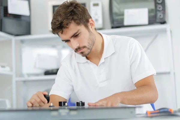 Junger Reparateur installiert Induktionsherd in Küche — Stockfoto