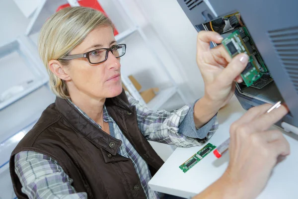 Girl with a tester and a printed circuit board — Stock Photo, Image