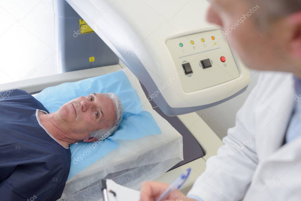 Male patient ready to undergo mri assisted by doctor
