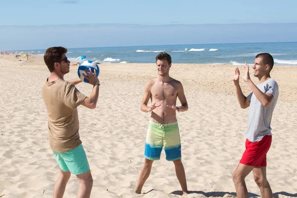 Tre Giovani Che Divertono Sulla Spiaggia Giocando Pallavolo — Foto Stock