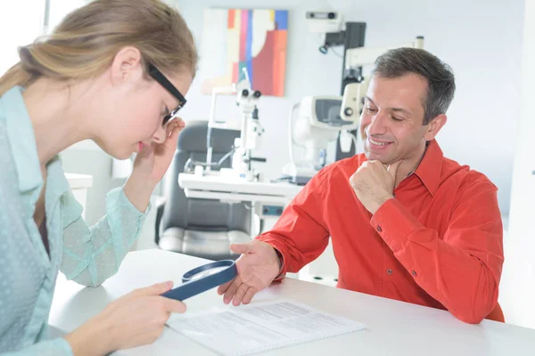 Frau Mit Brille Betrachtet Text Durch Ein Vergrößerungsglas — Stockfoto