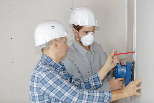 Young Builder Hardhat Sanding Wall Indoors — Stock Photo, Image