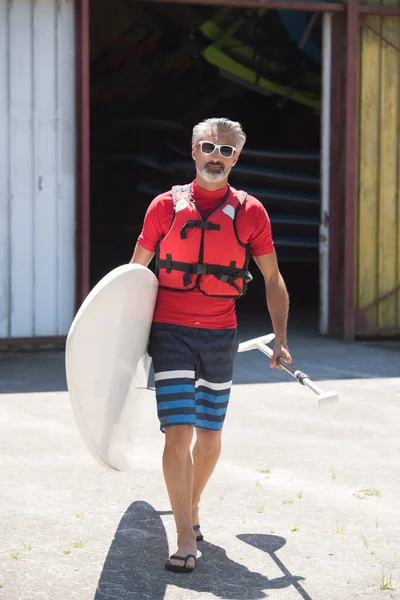 Uomo Tenendo Stand Paddle Board Camminando Verso Acqua — Foto Stock