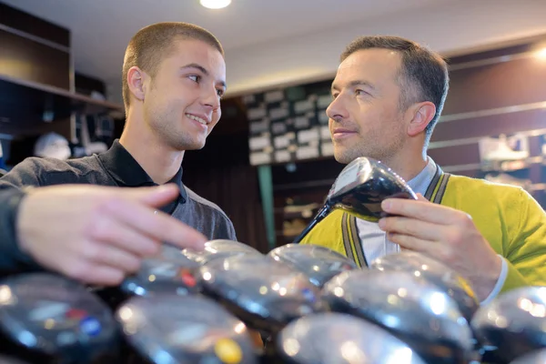 Szczęśliwy Sprzedawcy Klienta Przeglądanie Kluby Sklepie Golf — Zdjęcie stockowe