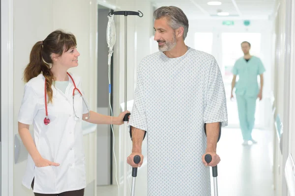 Krankenschwester Hilft Mann Mit Krücken Pflegeheim — Stockfoto