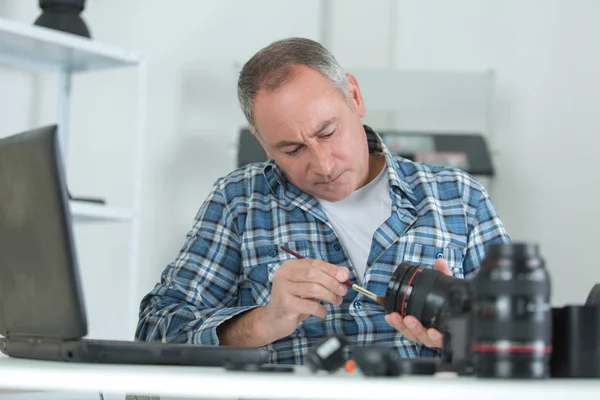 Mann Fixiert Kamera Und Repariert — Stockfoto