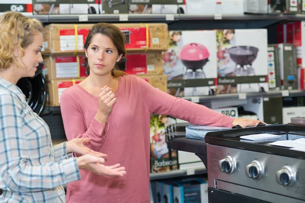 Vrouw Kijken Naar Bereik Fornuis Winkel — Stockfoto