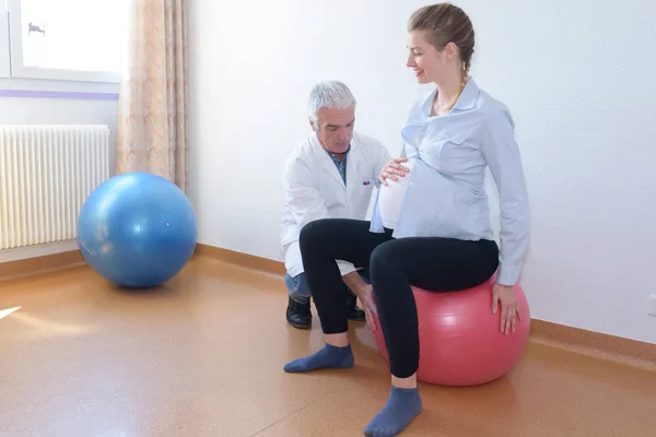 Médico Masculino Com Mulher Grávida Sentado Bola Fitness — Fotografia de Stock