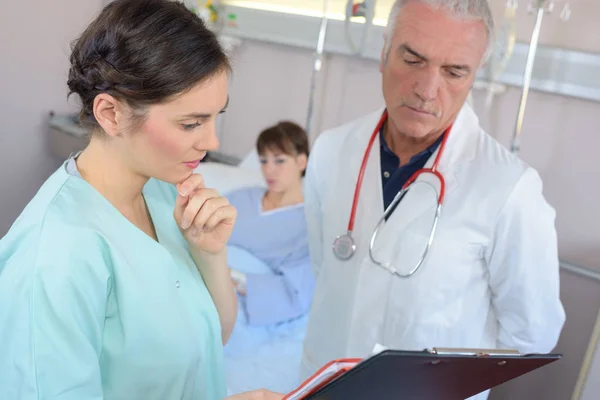 Médicos Deliberando Sobre Anotações Paciente — Fotografia de Stock