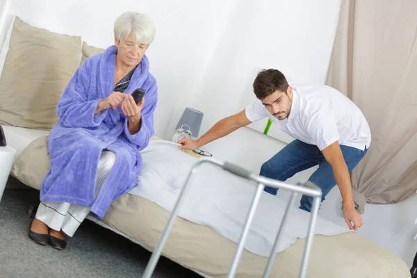 Senior Vrouw Met Wandelen Frame Terwijl Conciërge Maken Haar Bed — Stockfoto