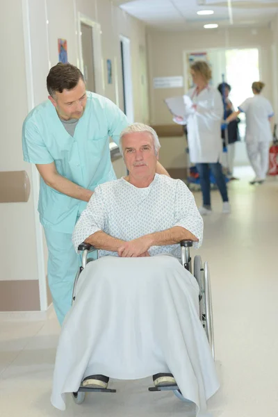 Krankenschwester Und Seniorin Rollstuhl Auf Krankenhausflur — Stockfoto