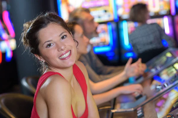 Belle femme en robe rouge jouant machine à sous — Photo