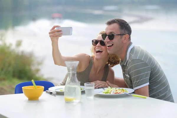 Coppia prendere selfie mentre si mangia pasto in acqua — Foto Stock