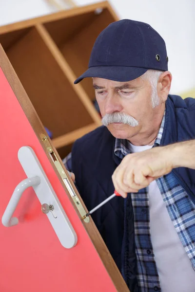 Profesional senior con diferentes tipos de llaves en cerrajero — Foto de Stock