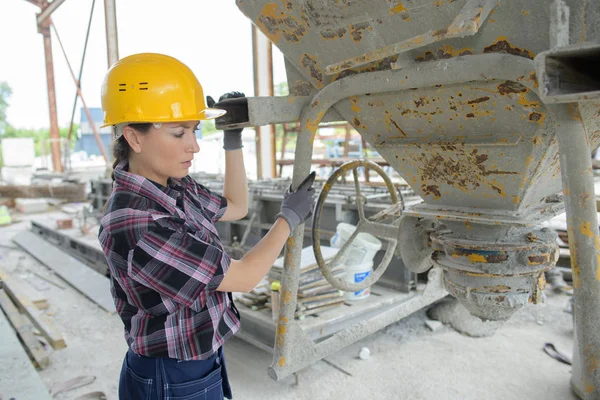 Arbeiterin mischt Zutaten im Betonmischer — Stockfoto