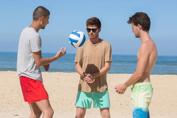 Счастливые друзья играют в пляжный мяч — стоковое фото