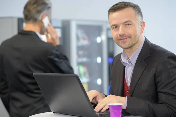 Knappe middelbare leeftijd zakenman achter een koffietafel — Stockfoto