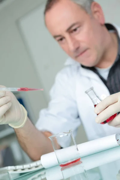 Investigador trabajando en un laboratorio con una pipeta de sangre — Foto de Stock