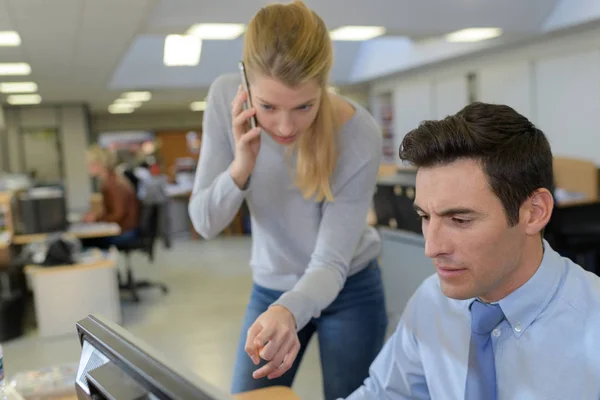 Mujer que ayuda al empleado de la computadora masculino — Foto de Stock