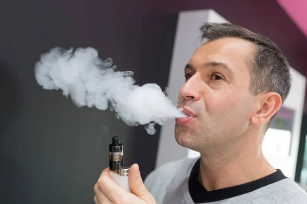 Man trying an e-cigarette in a shop — Stock Photo, Image