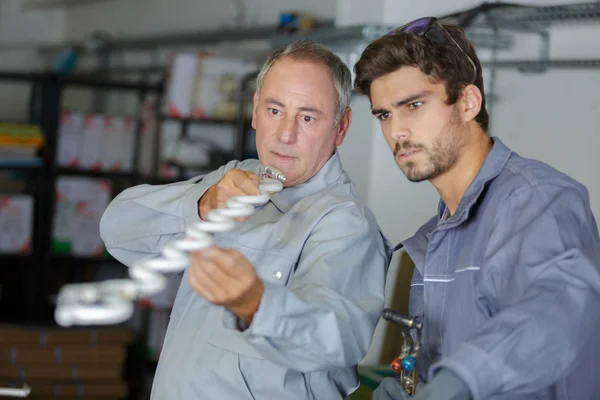 Fabrieksarbeiders en leerling — Stockfoto