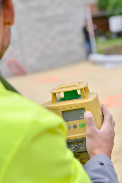 Landmeter-ingenieur is het meten van niveau op bouwplaats — Stockfoto