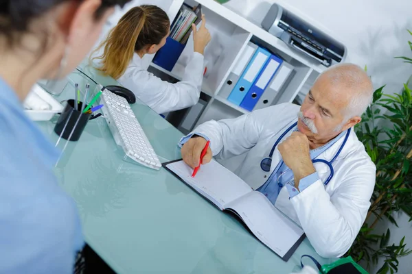 Läkare och patient på sjukhus kontor under regelbunden läkarundersökning — Stockfoto